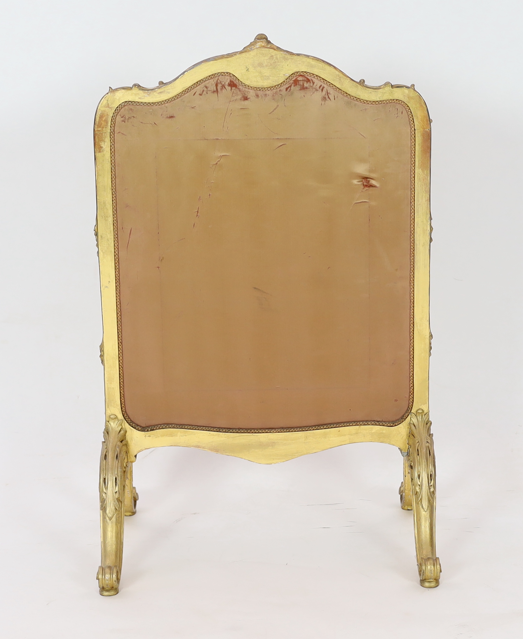 A Louis XV style carved giltwood framed fire screen, the silk panel printed with roundels of playful amorini, within naturalistic beadwork decorated foliage, 60cm wide, 93cm high. Condition - poor to fair, Please note th